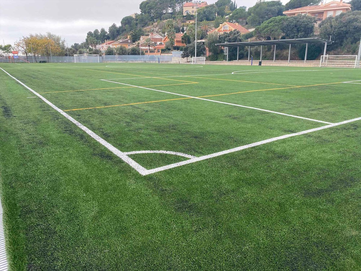 El camp de futbol llueix una impressionant catifa de gespa artificial d'última generació.